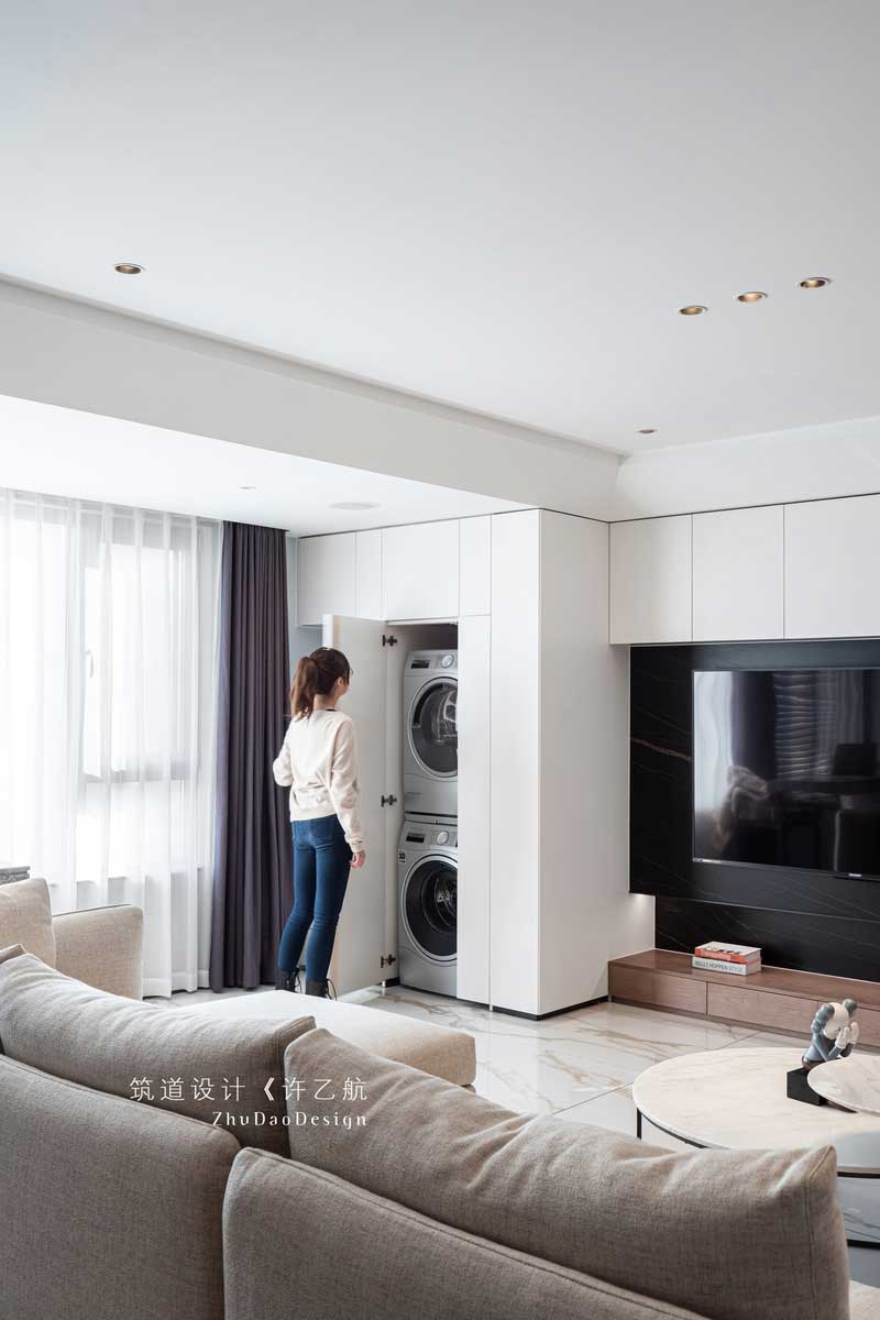 設計師充分利用陽臺的空間,把橫在客廳與陽臺的墻體打通,讓整個陽光通過大面積的窗戶照射進來,使整個空間采光通透;又將電視背景墻與之結合,并做了隱形門處理,將洗衣機、烘干機嵌入,既美觀又實用。 設計師充分利用陽臺的空間,把橫在客廳與陽臺的墻體打通,讓整個陽光通過大面積的窗戶照射進來,使整個空間采光通透;又將電視背景墻與之結合,并做了隱形門處理,將洗衣機、烘干機嵌入,既美觀又實用。