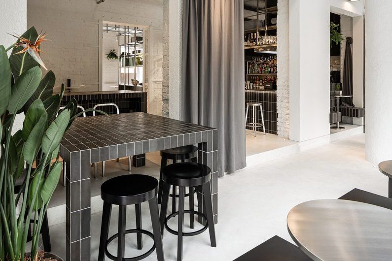簡約工業(yè)風咖啡廳黑色方磚餐桌搭黑色圓凳裝修圖